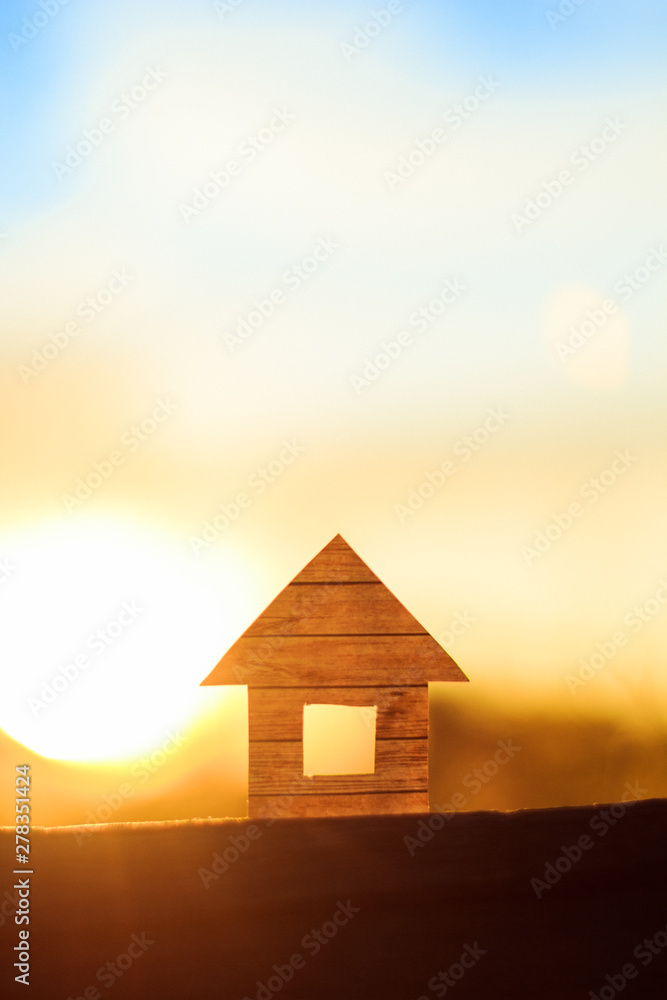 Conceptual paper house isolated on the sunset sky Conceptual paper house isolated on the sunset sky