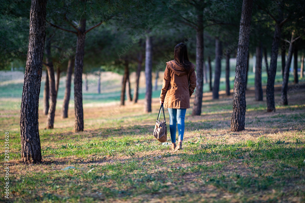 Beautiful woman standing on park during sunset Beautiful woman standing on park during sunset