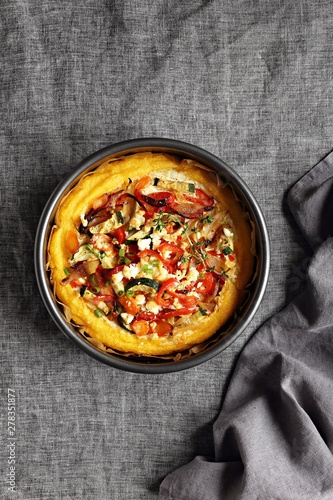 Polenta bake with vegetables and feta cheese. Overhead view. Copy space