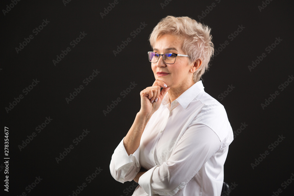 beautiful elderly woman in a white shirt and glasses on a black background beautiful elderly woman in a white shirt and glasses on a black background