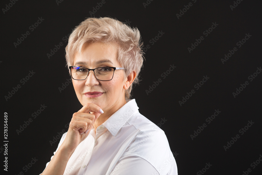 beautiful elderly woman in a white shirt and glasses on a black background