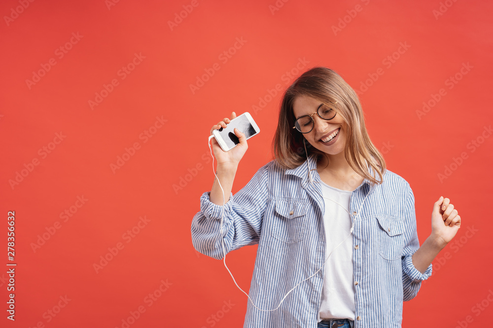 Smiling girl in casual clothes and earphones dancing moving hands. Smiling girl in casual clothes and earphones dancing moving hands.