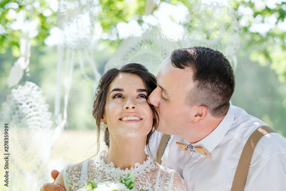 The groom kisses the happy bride