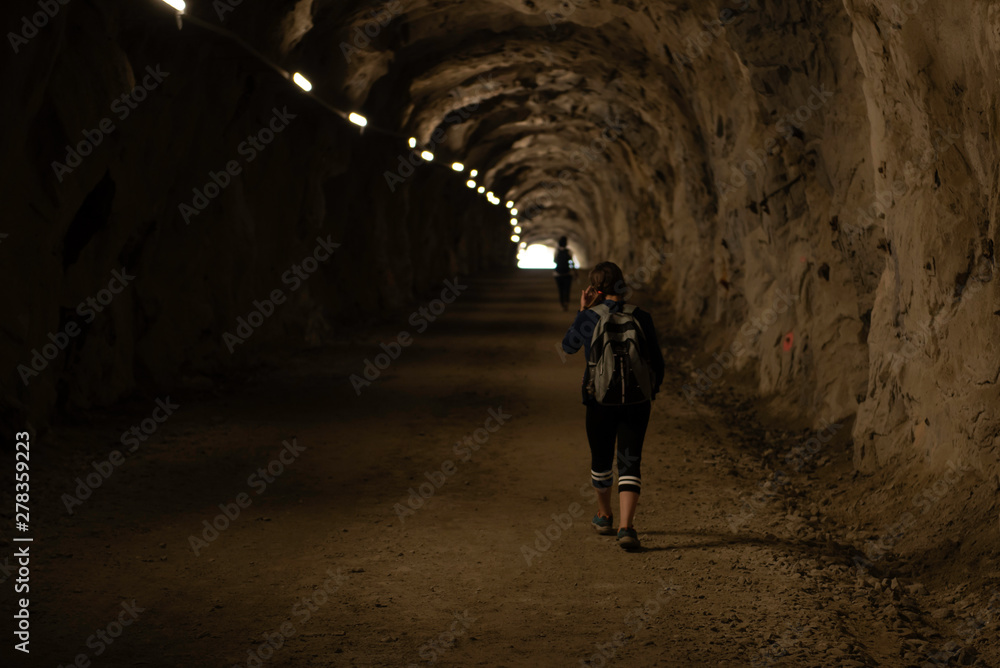 Girl walking through the tunnel, following her mother