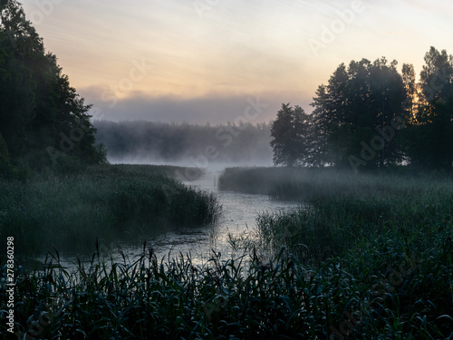 Foggy landscape with river. Early summer morning mist. Latvia