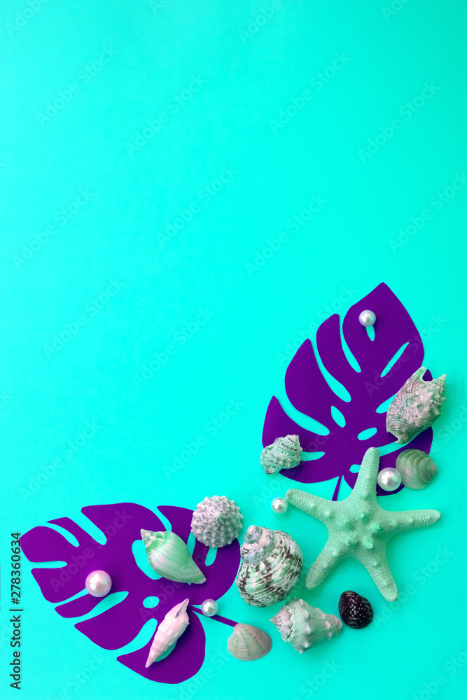 Fototapeta premium Vertical creative layout made of monstera leaves and seashells with copy space