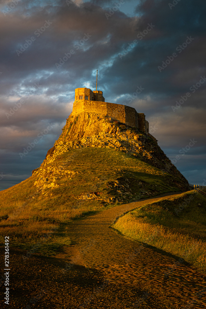 Obraz premium Dramatic Castle sunset near the Northumbria cost, England