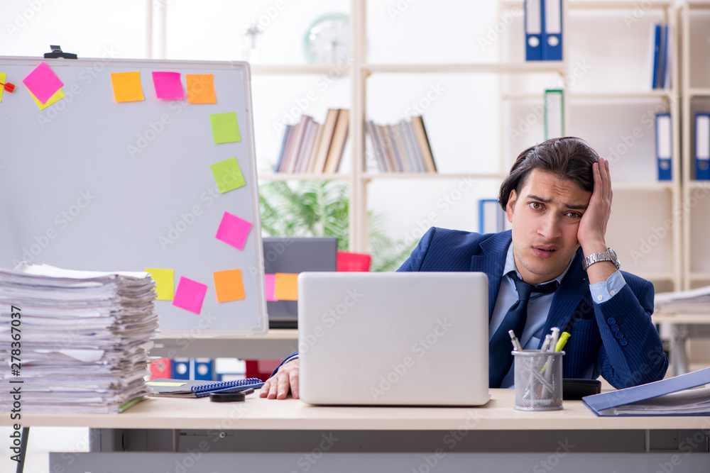 Young male employee unhappy with excessive work Young male employee unhappy with excessive work