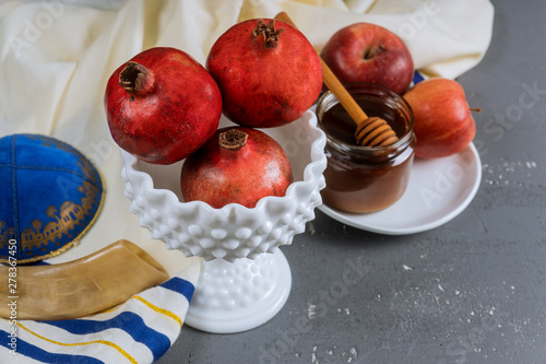 Apple and honey, traditional food of jewish New Year Rosh Hashana torah book, kippah yamolka talit photo