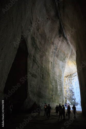 tourist silhouettes in the cave Ear of Dionysius , natural acoustic miracle © Moyseeva Irina