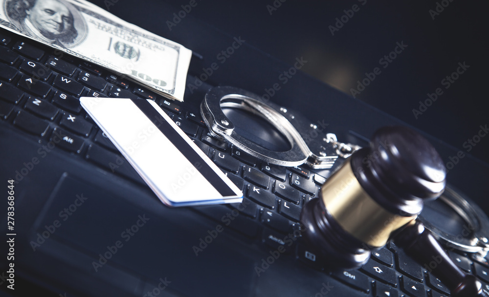 Handcuffs and Judge Gavel on laptop keyboard. Concept of Cyber crime and Online fraud Handcuffs and Judge Gavel on laptop keyboard. Concept of Cyber crime and Online fraud
