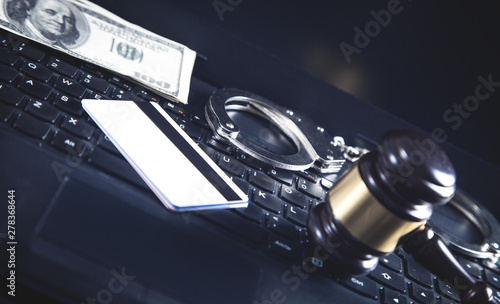 Handcuffs and Judge Gavel on laptop keyboard. Concept of Cyber crime and Online fraud