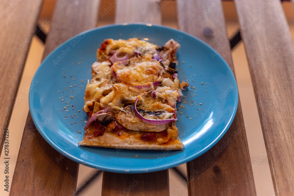 Homemade delicious pizza on a blue plate Homemade delicious pizza on a blue plate