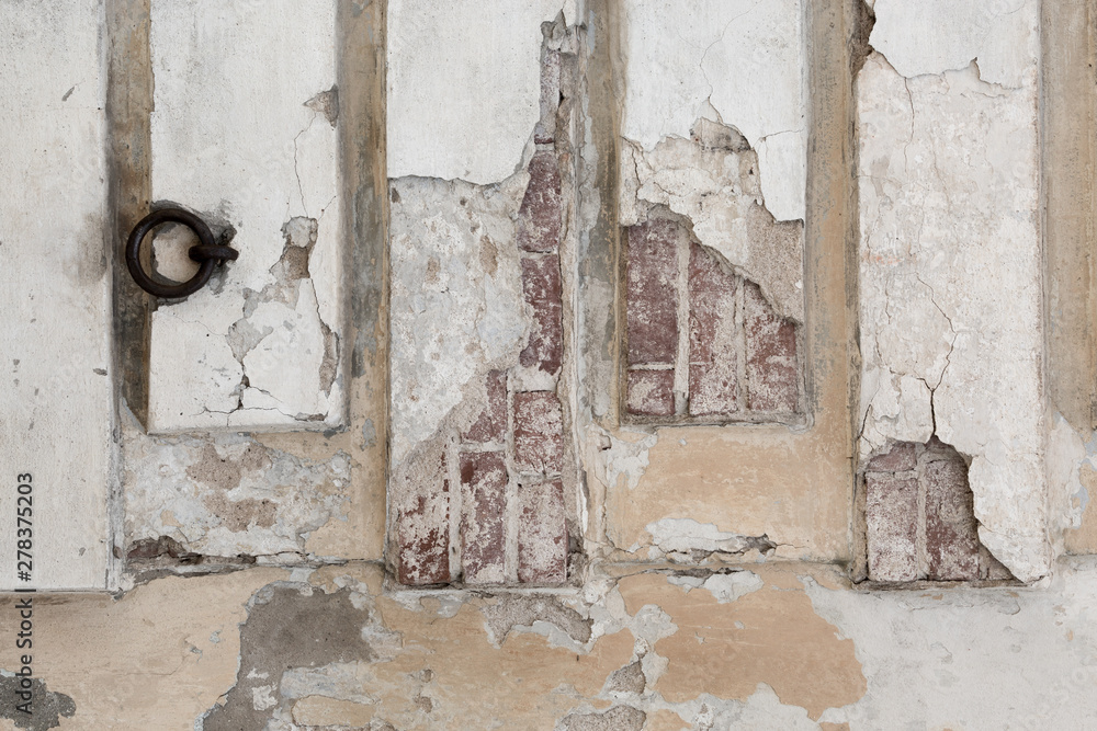 old shabby damaged plaster on the walls of houses close-up