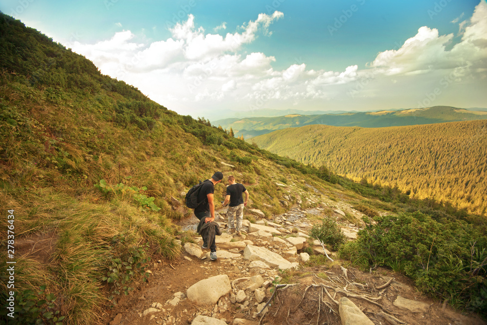 hiking in the mountains, two men walking on a mountain path