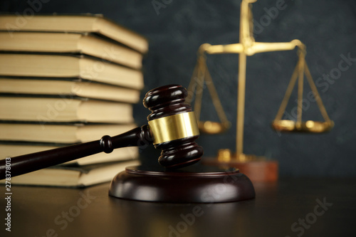 Judge gavel, scales of justice and law books in court