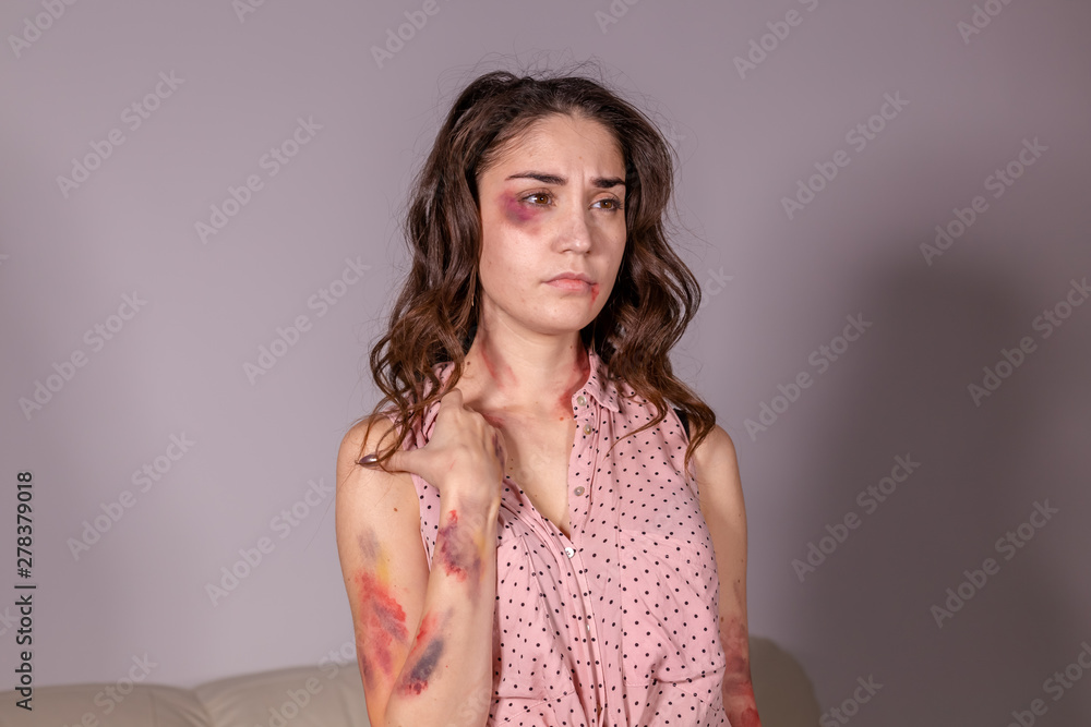Obraz premium violence issues - Woman victim of domestic violence and abuse over grey background