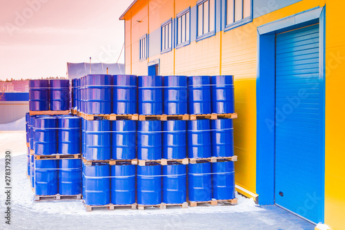 Blue containers palletized in stock. Plastic barrels for toxic products. Chemical storage tanks. Barrels for shipment from stock. Transport of hazardous substances. Warehouse work. Chemical industry.