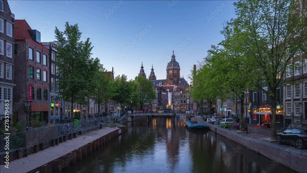 Amsterdam city skyline day to night time lapse with Church of Saint Nicholas landmark in Amsterdam city, Netherlands Amsterdam city skyline day to night time lapse with Church of Saint Nicholas landmark in Amsterdam city, Netherlands