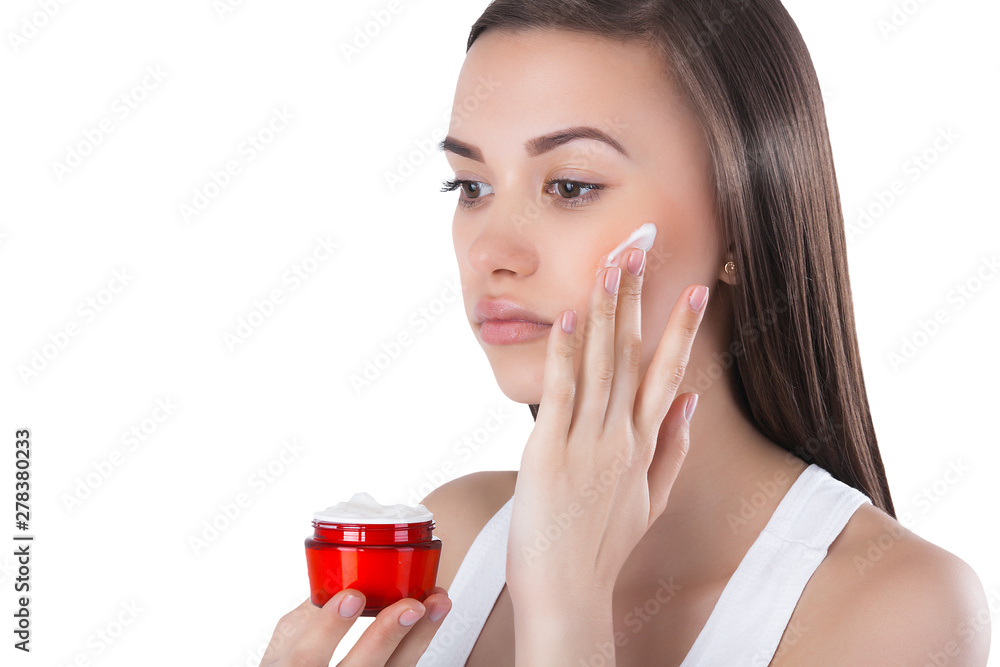 Closeup portrait of young attractive woman applying face cream. Female holding a jar with moisturizing face cream. Closeup portrait of young attractive woman applying face cream. Female holding a jar with moisturizing face cream.