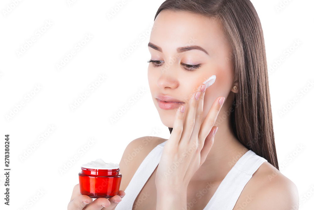 Closeup portrait of young attractive woman applying face cream. Female holding a jar with moisturizing face cream. Closeup portrait of young attractive woman applying face cream. Female holding a jar with moisturizing face cream.