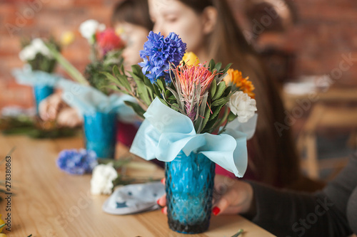 Floral maser-class. Women making a floral composition with fresh flowers. photo