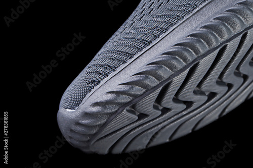 Fragment of a rubber black sole sneaker. Bottom of sports shoes