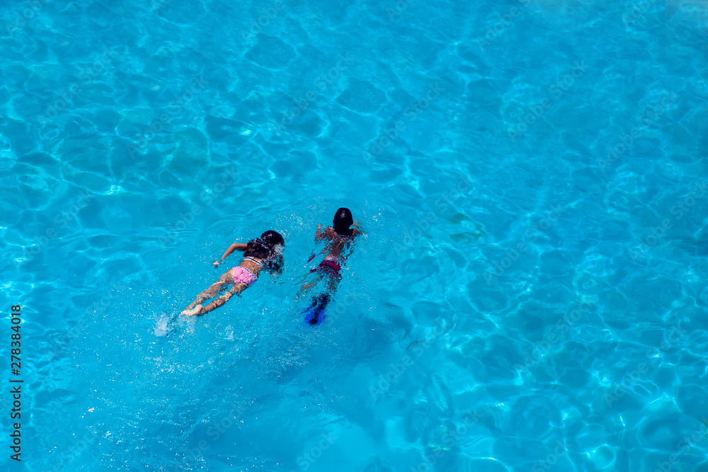 Children swim in the pool. Summer and vacation concept