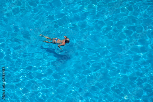 Woman swims in the pool. Summer and vacation concept