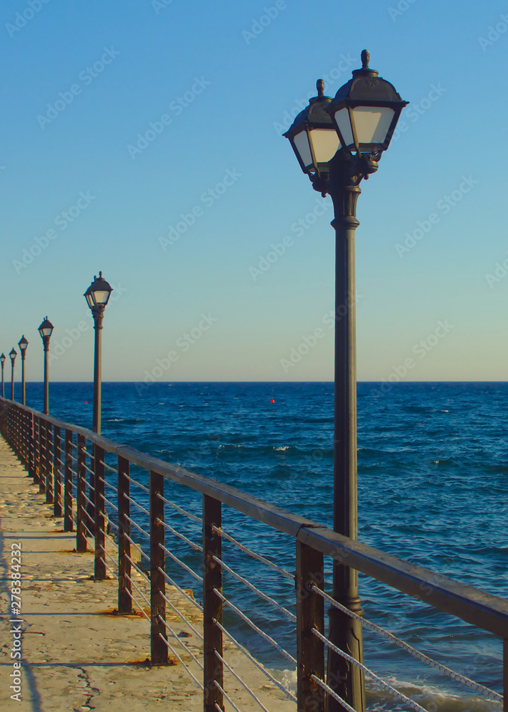 Street lights on sea pier on blue hour