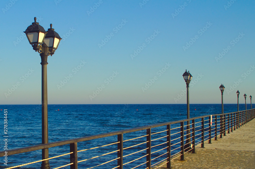 Street lights on sea pier on blue hour