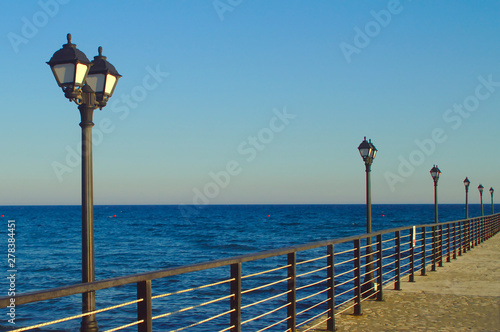 Street lights on sea pier on blue hour