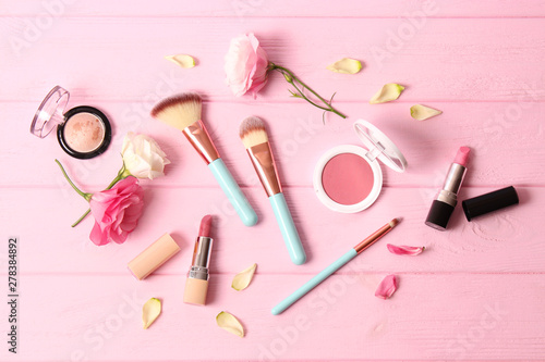 cosmetics and flowers on a colored background top view.