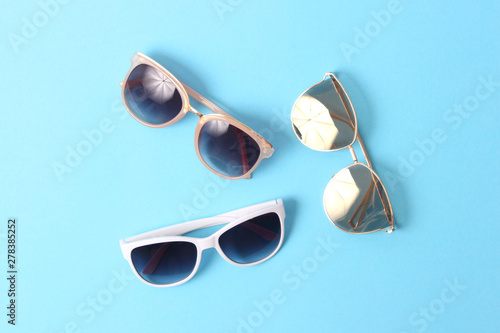 set of sunglasses on a colored background top view.