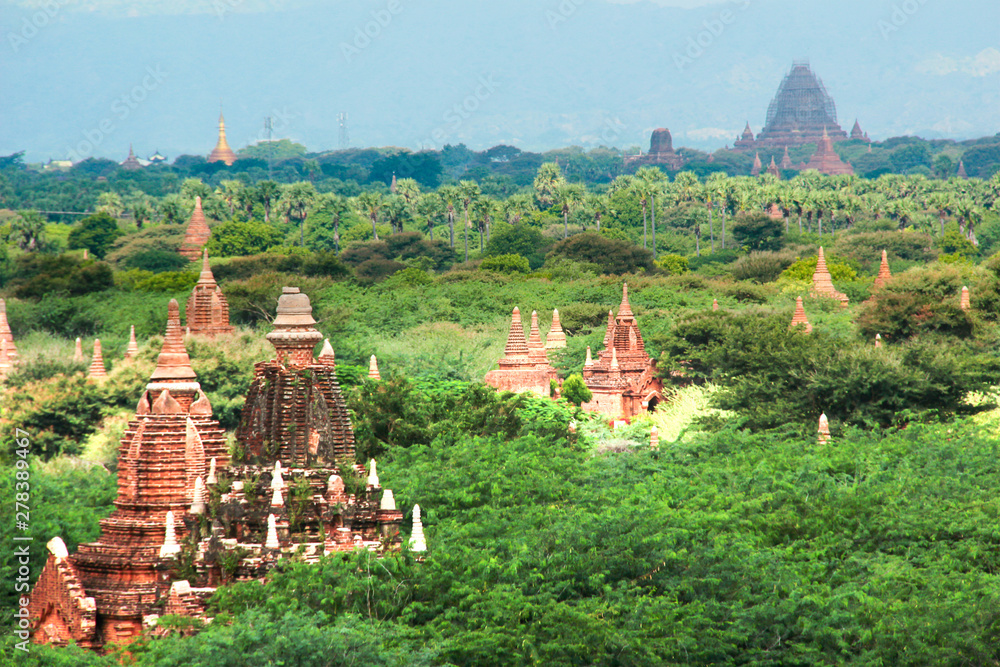 Peaks of old buddhist temples between trees in Bagan, Myanmar/Birma.