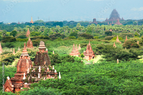 Peaks of old buddhist temples between trees in Bagan  Myanmar Birma.