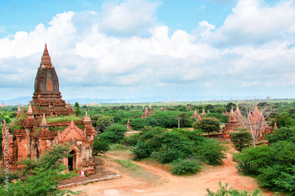 Old buddhist temples out of bricks between little paths and trees in Bagan, Myanmar/Birma.