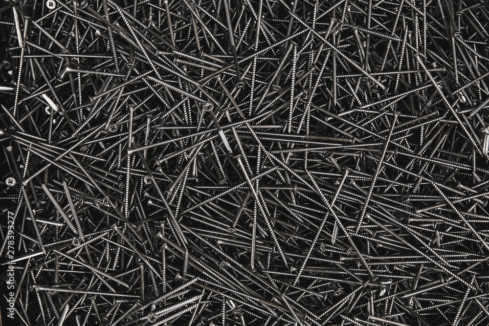 Pile of metal tapping chrome screws abstract background. Iron or metal screw nails stack industrial construction industry background. Pile of metal tapping chrome screws abstract background. Iron or metal screw nails stack industrial construction industry background.