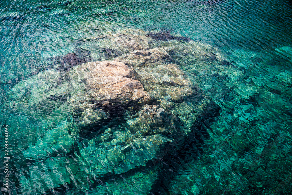 Türkises Wasser mit Fels in einem See