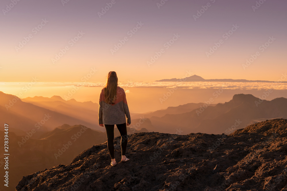 Happy young woman standing and enjoying life at sunset in mountains - gran canaria, spain