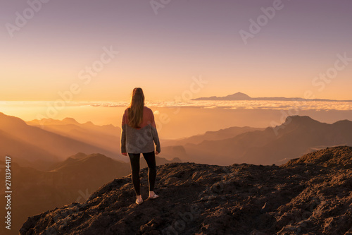 Happy young woman standing and enjoying life at sunset in mountains - gran canaria  spain