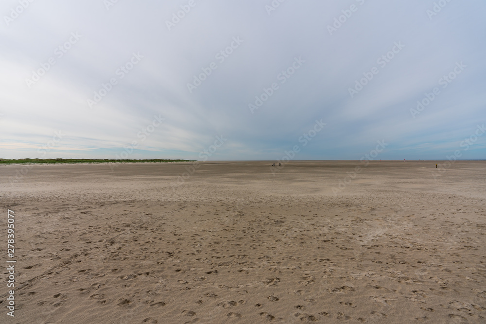 Langer einsamer Sandstrand am Meer mit Wolken Langer einsamer Sandstrand am Meer mit Wolken