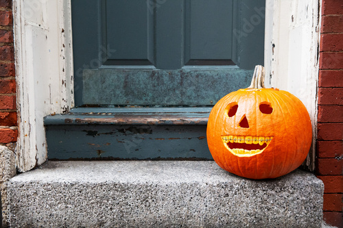 funny Halloween pumpkin on the doorstep. smiling pumpkin with braces. the concept of dentist office. copy space for your text photo