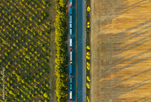 Trucks driving through the countryside. Aerial view from drone. Cargo driving