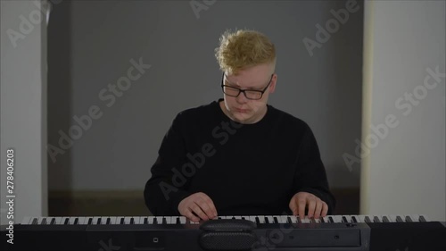 A composer with headphones playing the digital piano. Musician playing synthesizer photo