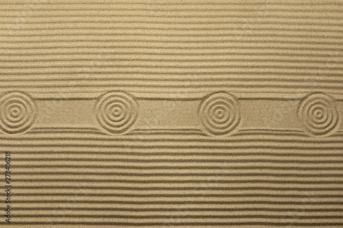 Circles and lines on the sand, with space for design, text place. Texture of sand.