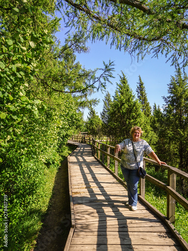 Mature woman tourist resting in a juniper Park by the river