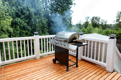 Fotótapéta Barbecue grill cooking with visual smoke in open outdoor deck during summer day