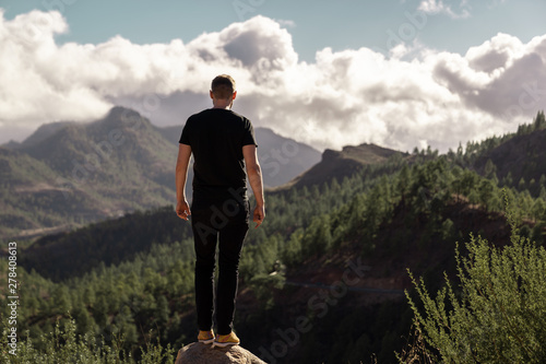 Happy young tall man from behind standing and enjoying life in the mountains of gran canaria, canary islands, spain