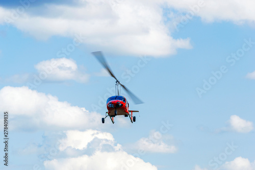 Red gyroplane in flight